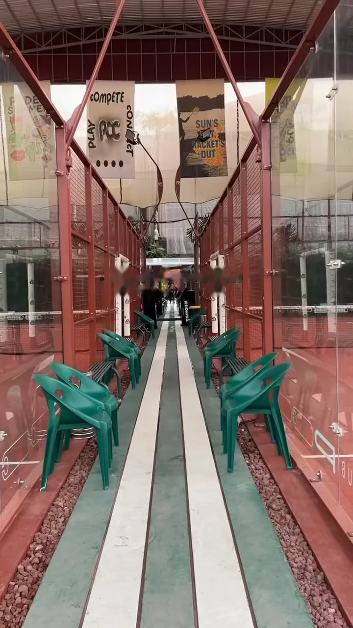 The walkway between courts, green chairs and green-and-white stripes underfoot