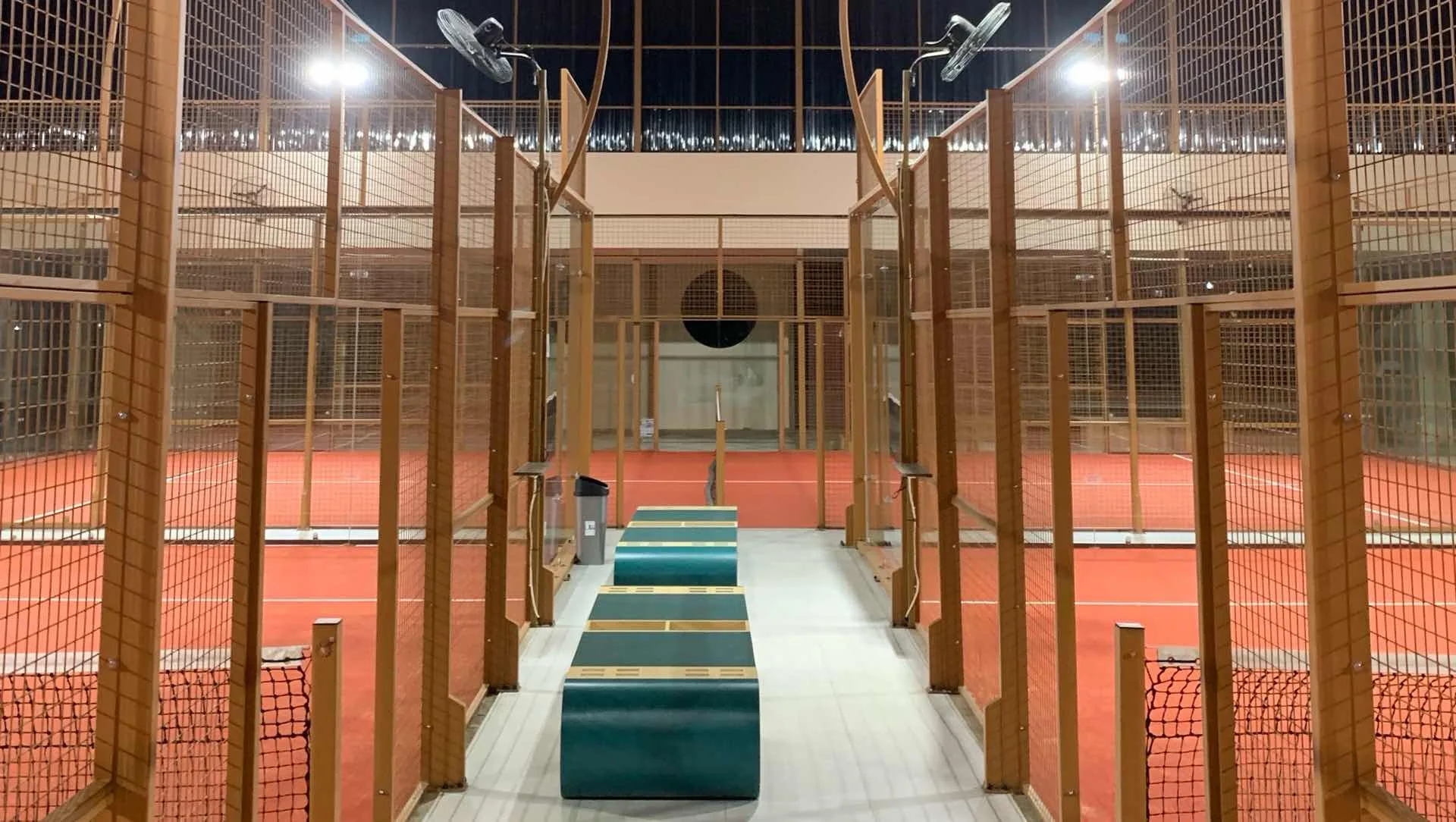 The walkway between two courts at night, timber frames and benches either side