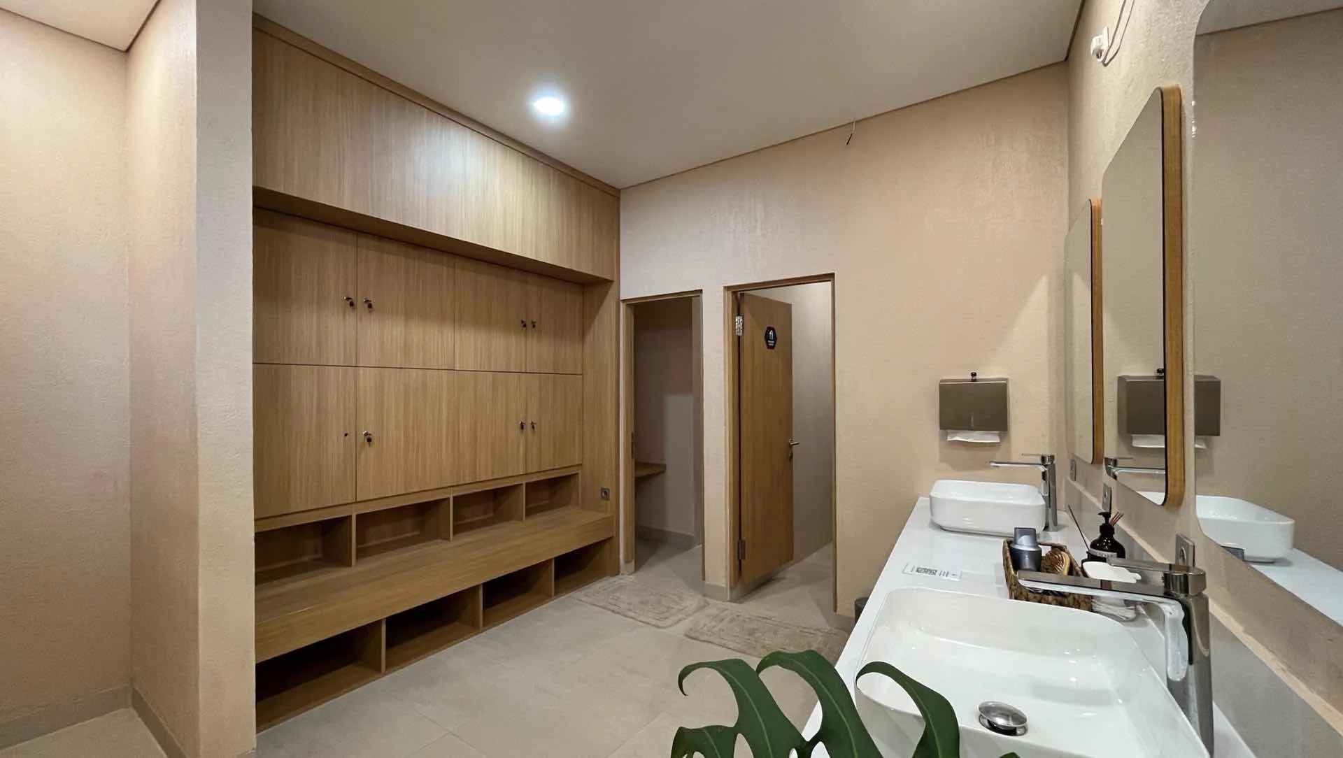 The changing room: timber lockers, a stone basin and a shower